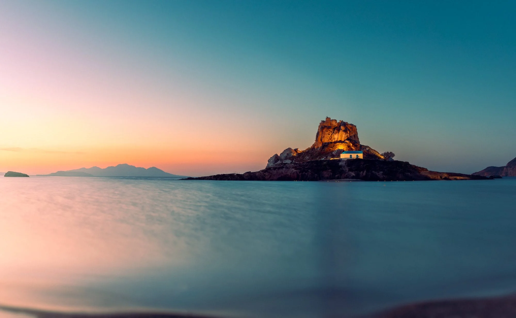 "The island of Kastri in Kos, Greece, featuring the small blue-domed chapel in the stillness of dawn. Fine art photography available as a 100% cotton canvas or Limited Edition Giclée print, featuring a 1.5-inch (3.8 cm) solid Latvian pine frame."